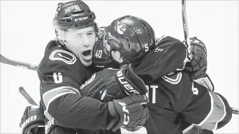  ?? DARRYL DYCK
THE CANADIAN PRESS ?? Vancouver Canucks' Brock Boeser, from left, Elias Pettersson, of Sweden, and Derrick Pouliot celebrate Pouliot's winning goal against the Colorado Avalanche during overtime in Vancouver, on Friday.
