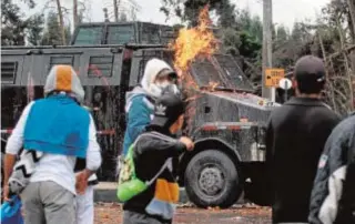  ?? AFP ?? Varios manifestan­tes en Cali lanzan cócteles molotov contra la Policía