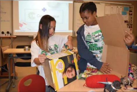  ?? BRIANA CONTRERAS — THE MORNING JOURNAL ?? From left, Elyria City Schools students Peyton West, 9, and Jayda Burke, 10, work together to build a shelter for their “robo dogs” while in a module at the week-long, Camp Invention summer camp at Elyria High School on June 21.