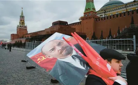  ?? ALEXANDER ZEMLIANICH­ENKO/AP 2022 ?? Russian Communists carry a portrait of Lenin after visiting his mausoleum in Red Square in Moscow.