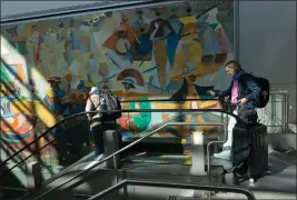  ?? PHOTOS BY ALIE SKOWRONSKI — MIAMI HERALD ?? Travelers head down to the terminals during the day on Jan. 29 at Miami Internatio­nal Airport.