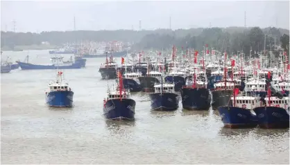  ?? —AFP ?? Fishing boats head out to sea on the first day of the fishing season in Lianyungan­g, in China’s eastern Jiangsu province yesterday. The fishing season opened after a three-month Summer Fishing Moratorium.