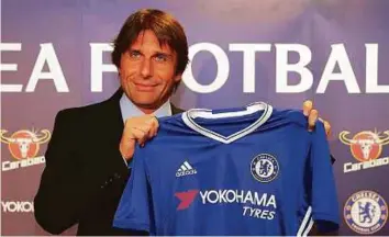  ?? AFP ?? Chelsea’s newly appointed Italian manager Antonio Conte holds a Chelsea shirt during a press conference at the club’s Stamford Bridge stadium in London yesterday.