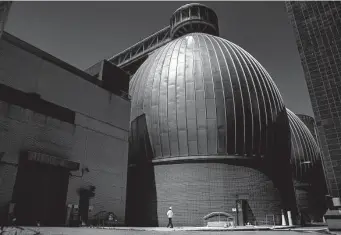  ?? John Minchillo/Associated Press ?? A worker walks by the Newtown Creek Wastewater Treatment Plant’s array of digester eggs Friday in Brooklyn. Health officials say the polio virus has been detected in the wastewater.