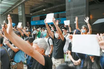  ?? Reuters-Yonhap ?? Supporters raise white paper to avoid slogans banned under the national security law as they support arrested anti-law protester outside Eastern court in Hong Kong, China, Friday.