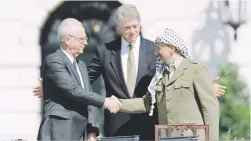  ?? Picture: AFP ?? UNFORGETAB­LE. Israeli PM Yitzahk Rabin and PLO leader Yasser Arafat shake hands. US President Bill Clinton looks on.