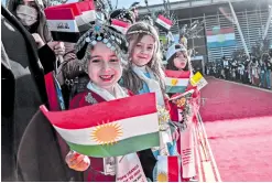  ?? —AFP ?? INNOCENTS Iraqi children wave Kurdish flags as they welcome Pope Francis upon his arrival at Arbil airport on Sunday.