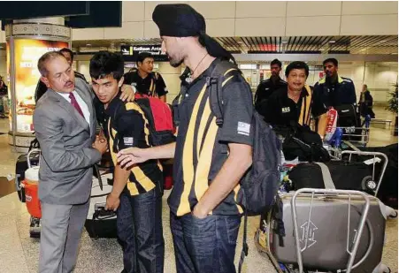  ??  ?? Back home: Malaysian Hockey Confederat­ion deputy president Datuk Nur Azmi Ahmad welcomes national hockey players Mohd Fitri Saari and Baljit Singh, who returned with the team from Dublin, yesterday.