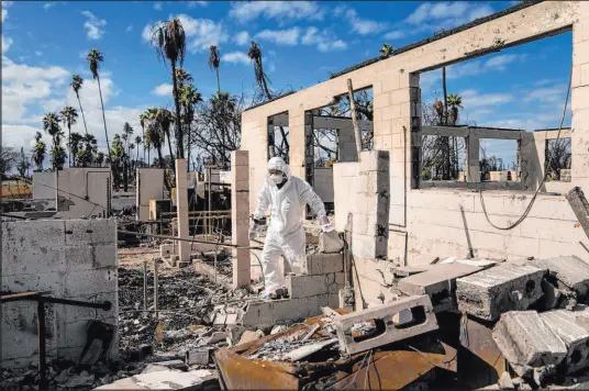  ?? Lindsey Wasson
The Associated Press ?? The Rev. Ai Hironaka walks Dec. 7 through the grounds of his temple and residence destroyed by wildfire in Lahaina, Hawaii.