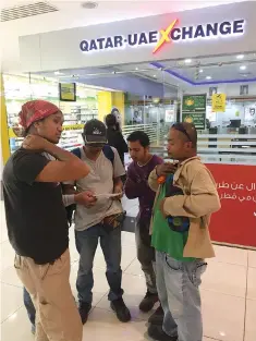  ??  ?? People stand outside Qatar-UAE Exchange House in Doha’s City Center mall, Qatar. Qatar’s own mostly small consumer businesses say they are finding new suppliers, which could alter establishe­d trading patterns in the Gulf. — Reuters photo