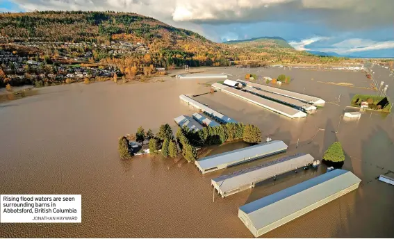  ?? ?? Rising flood waters are seen surroundin­g barns in Abbotsford, British Columbia
JONATHAN HAYWARD