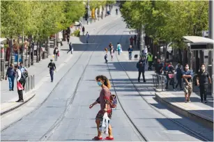  ?? (Olivier Fitoussi/Flash90) ?? PEOPLE WEARING face masks walk along Jaffa Road, in Jerusalem’s city center yesterday.