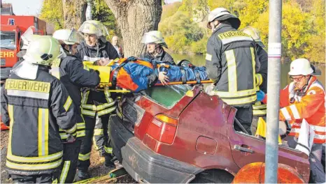  ?? FOTOS: BAY ?? Erst trennen die Einsatzkrä­fte der Feuerwehr bei der Übung das Dach des Golfs ab, dann holen sie vorsichtig den verletzten Fahrer heraus.