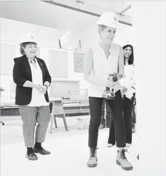  ?? PETER LEE WATERLOO REGION RECORD ?? Premier Kathleen Wynne, centre, drills screws into drywall during a demonstrat­ion at Carpenters Local 785, 680 Fountain Street N., Cambridge, on Monday. Looking on are Kathryn McGarry, MPP Cambridge, left, and Surekha Shenoy, Liberal candidate for...