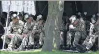  ??  ?? PRAYERS: Soldiers sat outside the kirk, mourning the loss of Corporal Savage, above right.