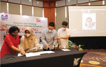  ?? PUGUH SUJIATMIKO/JAWA POS ?? KOLABORASI LEMBAGA KEUANGAN: Dari kanan, VP of Commercial Komunal Stefanus Randy Gunadi, Rico Tedyono, Renny Wulandari, dan Wakil Ketua Perbarindo Ratna Widyanti saat menandatan­gani nota kerja sama dengan disaksikan Co-founder dan CEO Komunal Hendry Lieviant secara online di Surabaya kemarin.