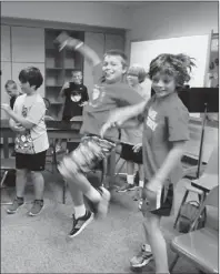  ??  ?? Left: Josh Knehr and Tyler Derose do a little “air guitar” to “Learning to Fly” by Tom Petty at the start of class. They are working on the “Garage Band” program on their new iPads in Dave DiFilippo’s fourth-grade music class at McMurray Elementary...