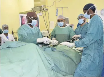  ??  ?? TA team of doctors perform a bilateral inguinal hernia surgery in April 2019 at the Mandeville Regional Hospital.