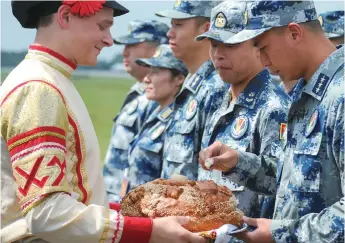  ??  ?? Chinese military officers are offered bread and salt upon arrival.