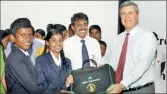  ??  ?? HSBC CEO for Sri Lanka and the Maldives Nick Nicolaou handing over study packs to students of Hewavithar­ana Vidyalaya in the presence of their principal