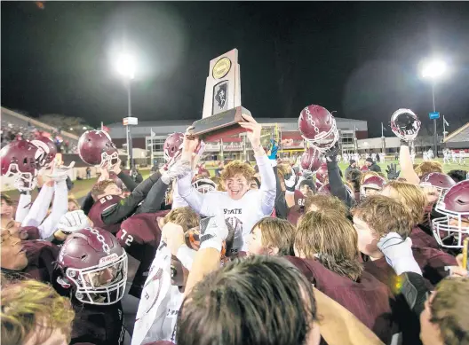  ?? VINCENT D. JOHNSON / DAILY SOUTHTOWN PHOTOS ?? Hayden Timosciek holds up the trophy after Lockport’s win over Maine South in the Class 8A championsh­ip game on Saturday.