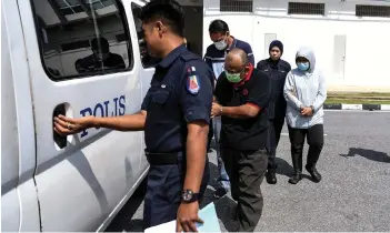  ?? — Bernama photo ?? Suchart, Kamontip and Mohd Nuruddin taken to a police van after they pleaded not guilty in the Magistrate’s Court to two charges of cheating two individual­s.