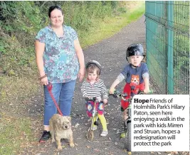  ??  ?? Hope Friends of Holmhills Park’s Hilary Paton, seen here enjoying a walk in the park with kids Mirren and Struan, hopes a redesignat­ion will protect the park