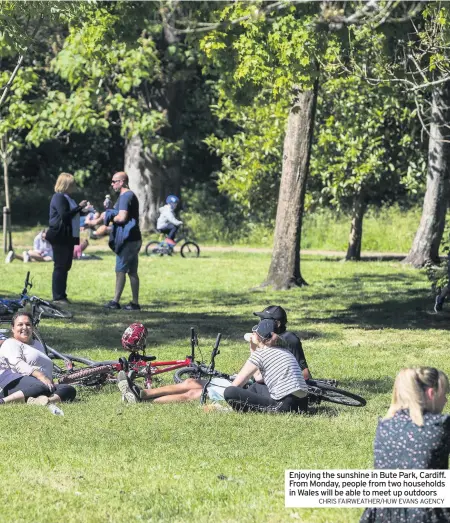  ?? CHRIS FAIRWEATHE­R/HUW EVANS AGENCY ?? Enjoying the sunshine in Bute Park, Cardiff. From Monday, people from two households in Wales will be able to meet up outdoors