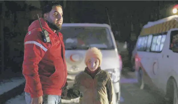  ?? PICTURE: AP ?? 0 A member of the Syrian Arab Red Crescent stands with his daughter as he helps with the evacuation of sick people from eastern Ghouta