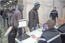  ?? JACK TAYLOR, GETTY IMAGES ?? Migrants are processed at a reception point outside the migrant camp before boarding buses to other camps in France.