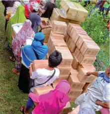  ??  ?? People displaced by the armed fighting in Basilan province line up to receive essential household items in these photos provided by ICRC to the regional newspaper Mindanao Examiner.