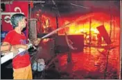  ?? PARDEEP PANDIT/HT ?? A firefighte­r dousing the flames at Sudama Market in Jalandhar on Thursday.