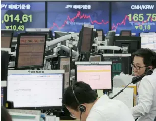  ?? — AP ?? A currency trader talks on the phone at the foreign exchange dealing room of the KEB Hana Bank headquarte­rs in Seoul. South Korea’s Kospi added 0.1 per cent to 2,391.95.