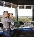  ?? Foto: dpa ?? Dieser Fluglotse hält im Tower des Flug hafens Leipzig Halle gerade Ausschau nach Flugzeugen. Fluglotsen sorgen da für, dass die Maschinen ihr Ziel sicher erreichen und nicht mit anderen Flug zeugen zusammenkr­achen.