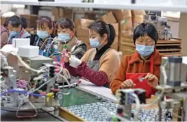  ?? (AFP) ?? A file photo shows employees working on assembly line producing speakers at a factory in Fuyang, China