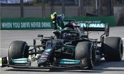  ?? Nelson Almeida/AFP/Getty Images ?? Lewis Hamilton was fined after taking off his seatbelt to accept a Brazilian flag on his in-lap after his momentous victory. Photograph: