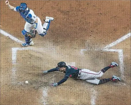  ?? Photog r aphs by Robert Gauthier Los Angeles Times ?? THE THROW gets past Dodgers catcher Will Smith as Atlanta’s Nick Markakis scores on a double by Cristian Pache off Tony Gonsolin to give the Braves a 3- 0 lead in the f if th inning. The advantage grew to 7- 0 before the Dodgers began a late rally.