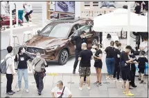  ??  ?? Visitors gather near an automobile promotion event in Beijing on Sunday,
Aug 30, 2020. (AP)