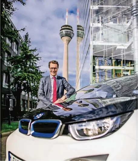  ??  ?? Vor der Fahrt mit dem E-Auto: NRW-Verkehrsmi­nister Hendrik Wüst vor dem Stadttor in Düsseldorf.