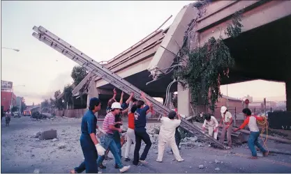  ?? TOM VAN DYKE — STAFF FILE PHOTO ?? Rescuers push up a ladder to reach the collapsed upper deck of the Cypress structure in Oakland on Oct. 17, 1989, shortly after the Loma Prieta earthquake.