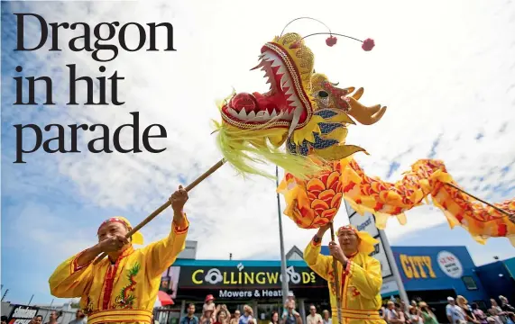  ??  ?? The yellow Chinese dragon stands out as it winds its way down Anglesea St during the Christmas parade.