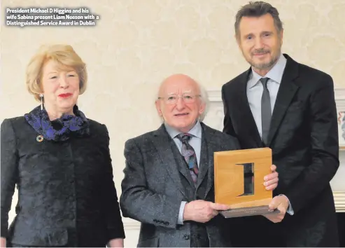  ??  ?? President Michael D Higgins and his wife Sabina present Liam Neeson with a Distinguis­hed Service Award in Dublin