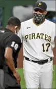 ?? Matt Freed/Post-Gazette ?? Wearing a mask, Pirates manager Derek Shelton argues with home plate umpire Ramon De Jesus, who also has a mask on, during this unique season in the midst of a pandemic