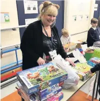  ??  ?? Larkfield teacher Janice Kenrick gets into the spirit at the bring and buy for Children in Need, left, and, right, school councillor­s on shift behind their stall