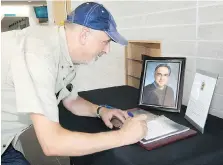  ??  ?? Bill Pignanelli signs a book of condolence­s for the late Sergio Marchionne at Windsor City Hall on Wednesday.