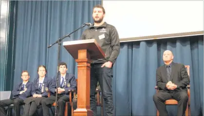  ??  ?? Michael McLean, wearing his Elite Motor Sport Academy Team of 2016 jacket, speaks at the Dannevirke High School assembly.