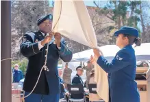  ?? EDDIE MOORE/JOURNAL ?? Sgt. Matt Jenkins, left, with the New Mexico Army National Guard, and Senior Airman Simone Cremeans, with the U.S. Air Force, take down the white flag near the end of the Bataan commemorat­ive ceremony.