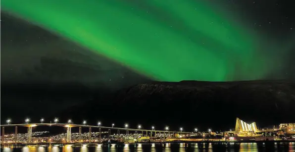  ?? DPA-BILD: GAUTE BRUVIK ?? Nordlichte­r über Tromsø: Das Himmelsphä­nomen lässt sich im Norden Europas in den Wintermona­ten beobachten.