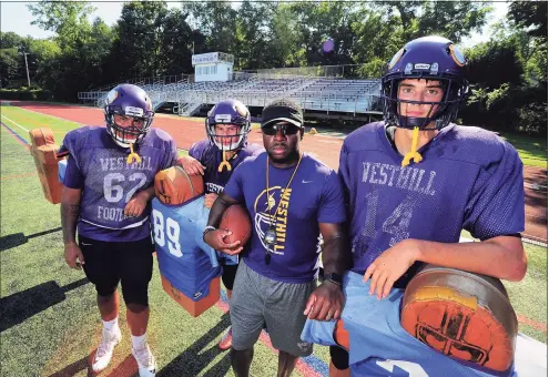  ?? Christian Abraham / Hearst Connecticu­t Media ?? Westhill High School football coach Aland Joseph, center with ball, poses with his captains during practice at the school in Stamford on Aug. 24. Captains with Coach Joseph from left to right are Carlos Escobar, Estuardo Diaz, and Sam Engel.