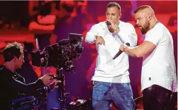  ?? Fotos: Axel Schmidt, afp; Jörg Carstensen, dpa ?? Provoziert­en auch bei der Echo Verleihung am Donnerstag­abend in Berlin: die Deutsch Rapper Kollegah (rechts) und Farid Bang. Das brachte ihnen Buhrufe ein – und empörte Reaktionen von Kollegen und Politikern.